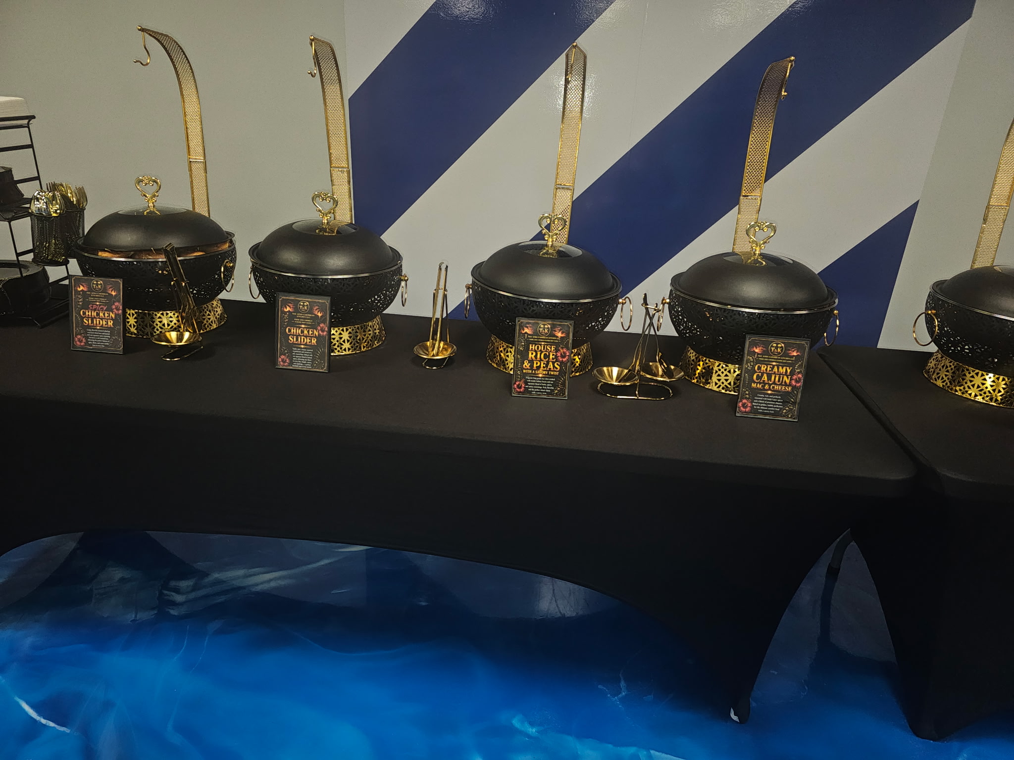 Black and gold chafing dish setup with Creamy Cajun Mac and Cheese and House Rice & Peas