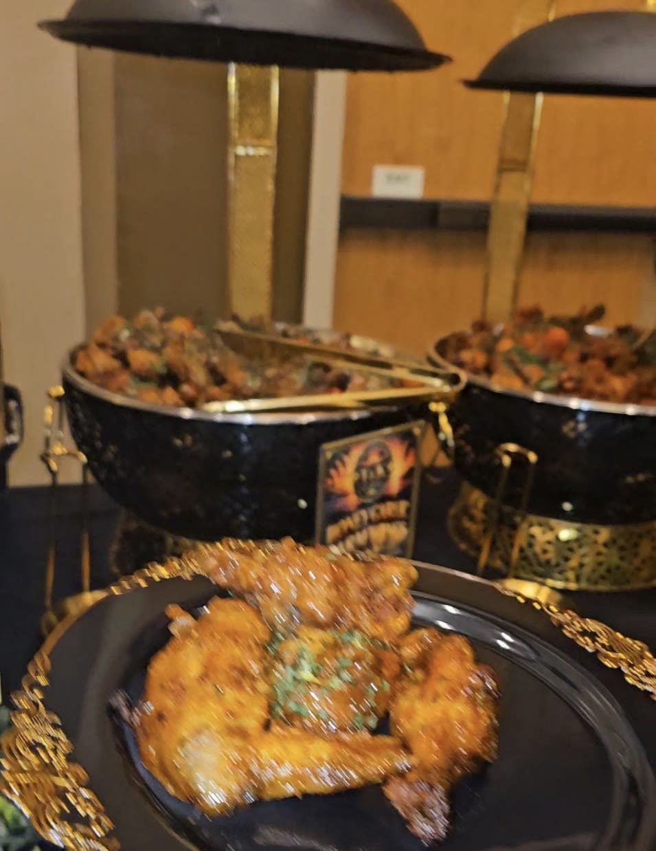 Golden glazed Caribbean wings plated on a gold-rimmed charger