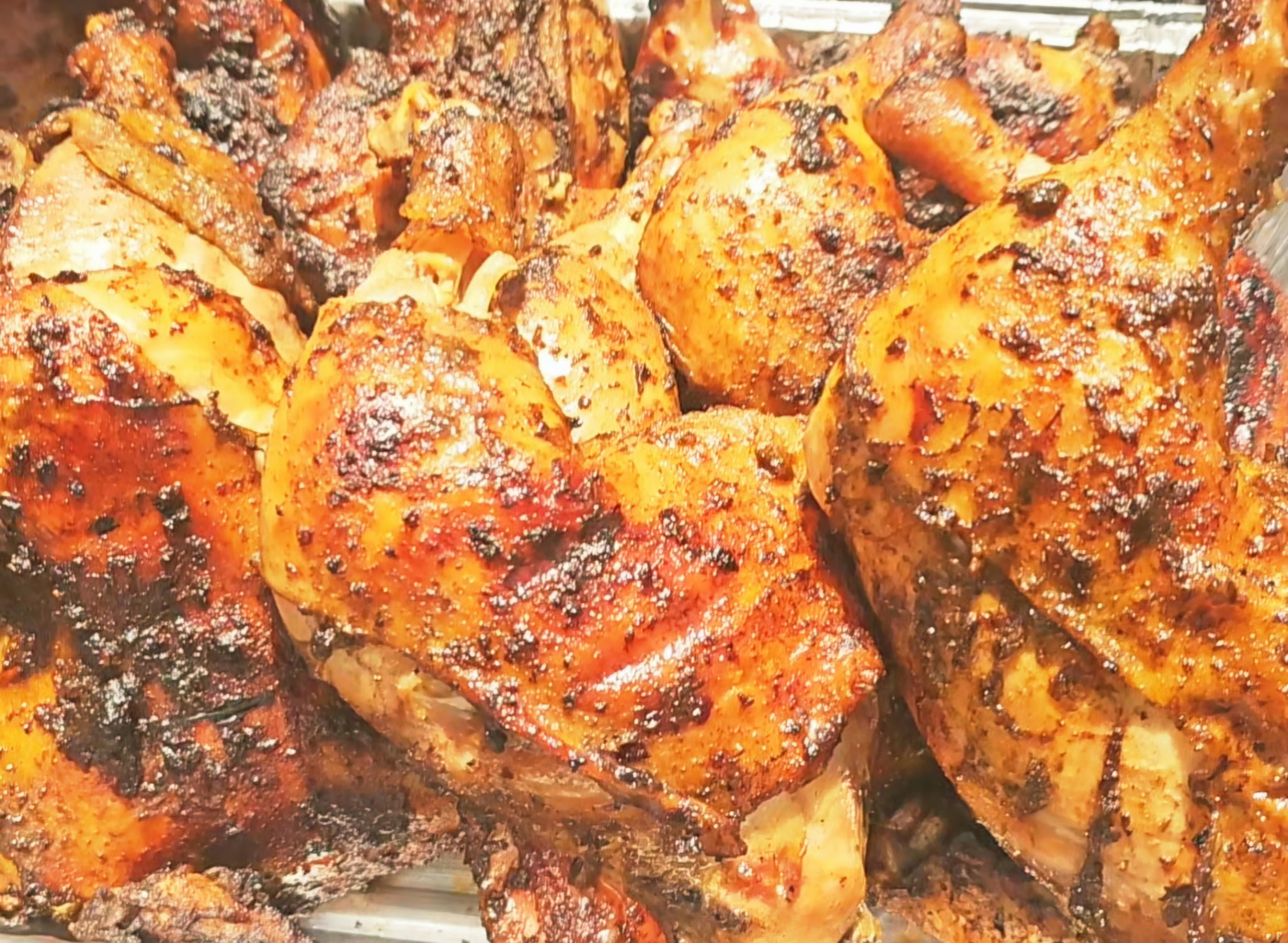 Tray of caramelized roasted chicken with house jerk seasoning