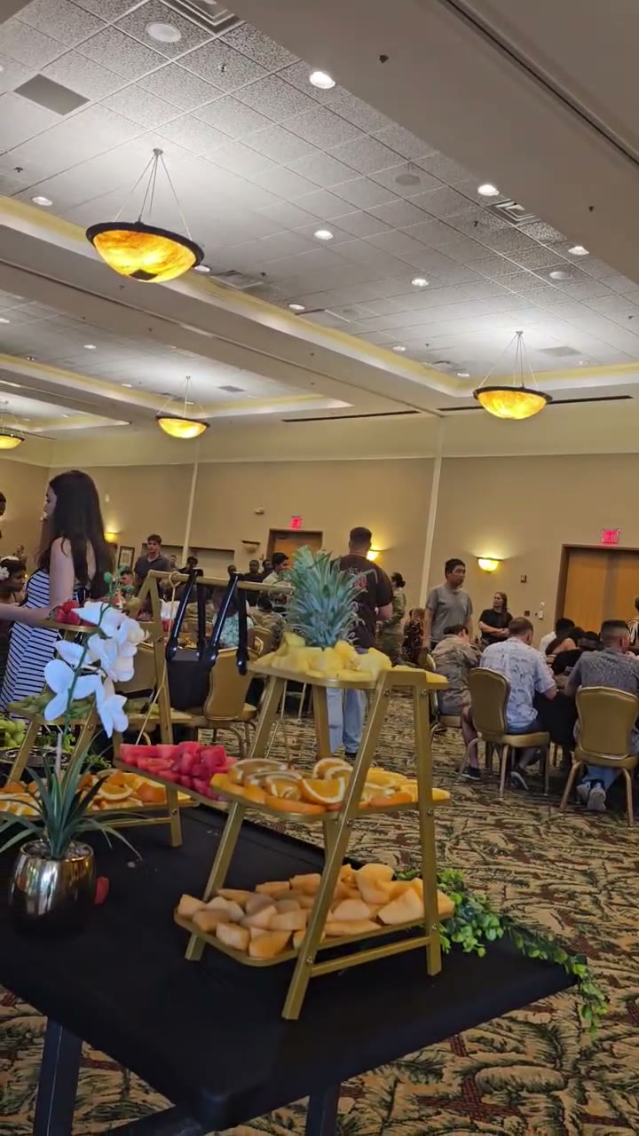 Video: guests and service members at a live T&K catered ballroom event with a tiered fresh fruit display