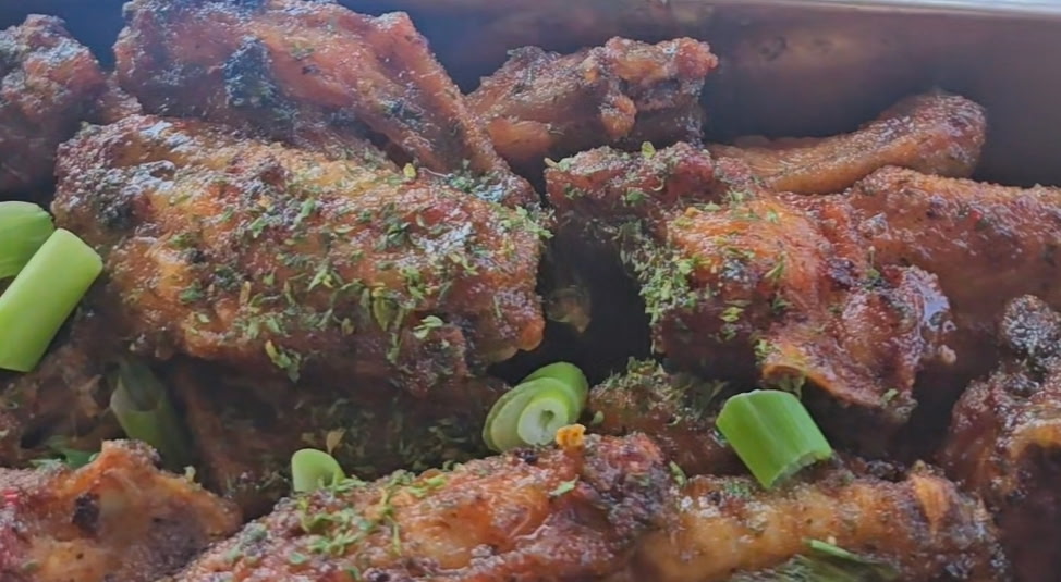 Herb-dusted Afro-Caribbean wings garnished with sliced green onion